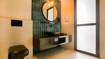 A modern bathroom with a black sink, a mirror, and a toilet.