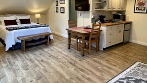 A compact room with a bed, a dining table, and a kitchenette. - Happy Valley Studio - Peaceful rest in nature, just 5 minutes from downtown!  (Anacortes)