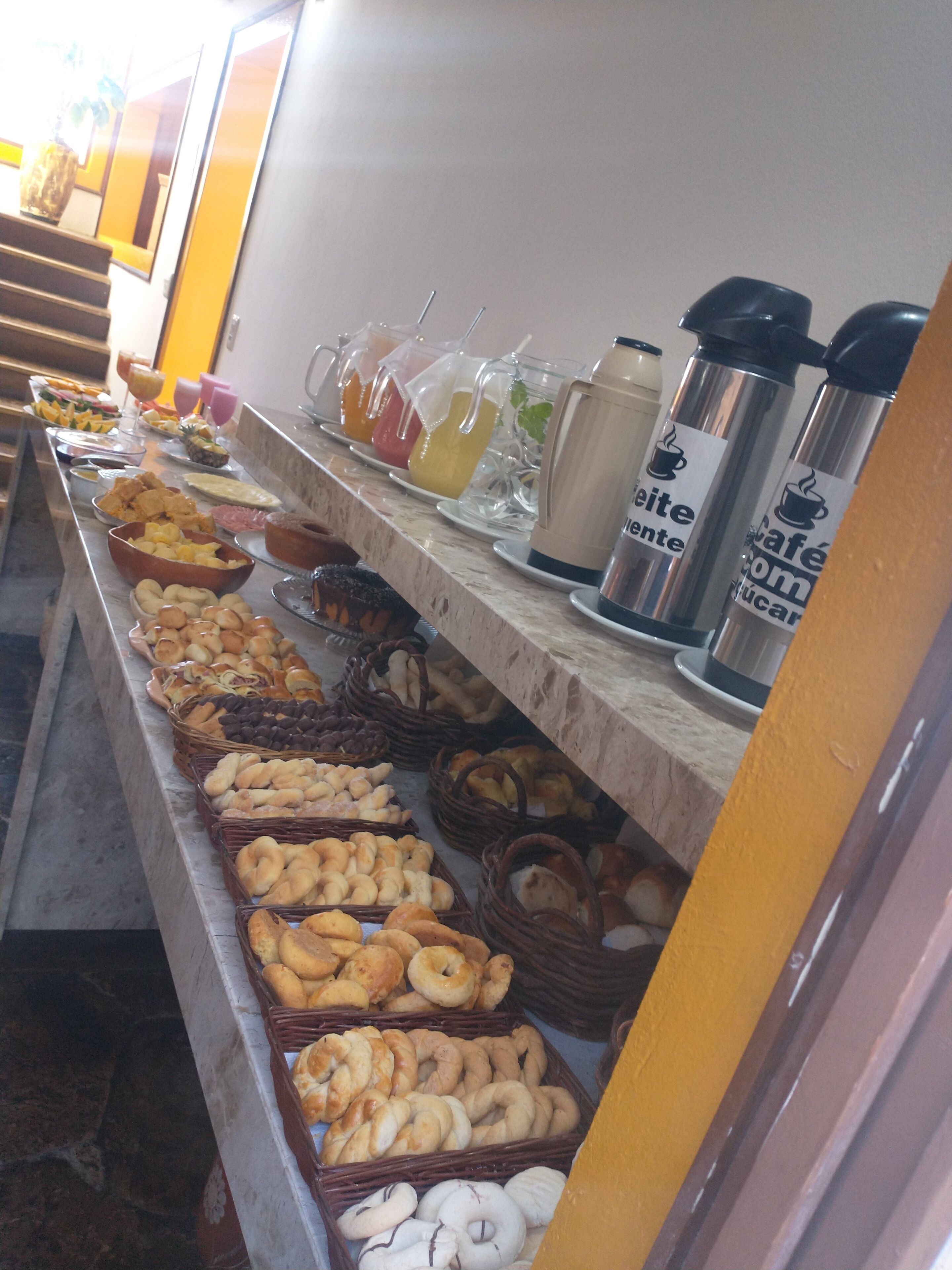 A buffet with various baked goods and beverages.