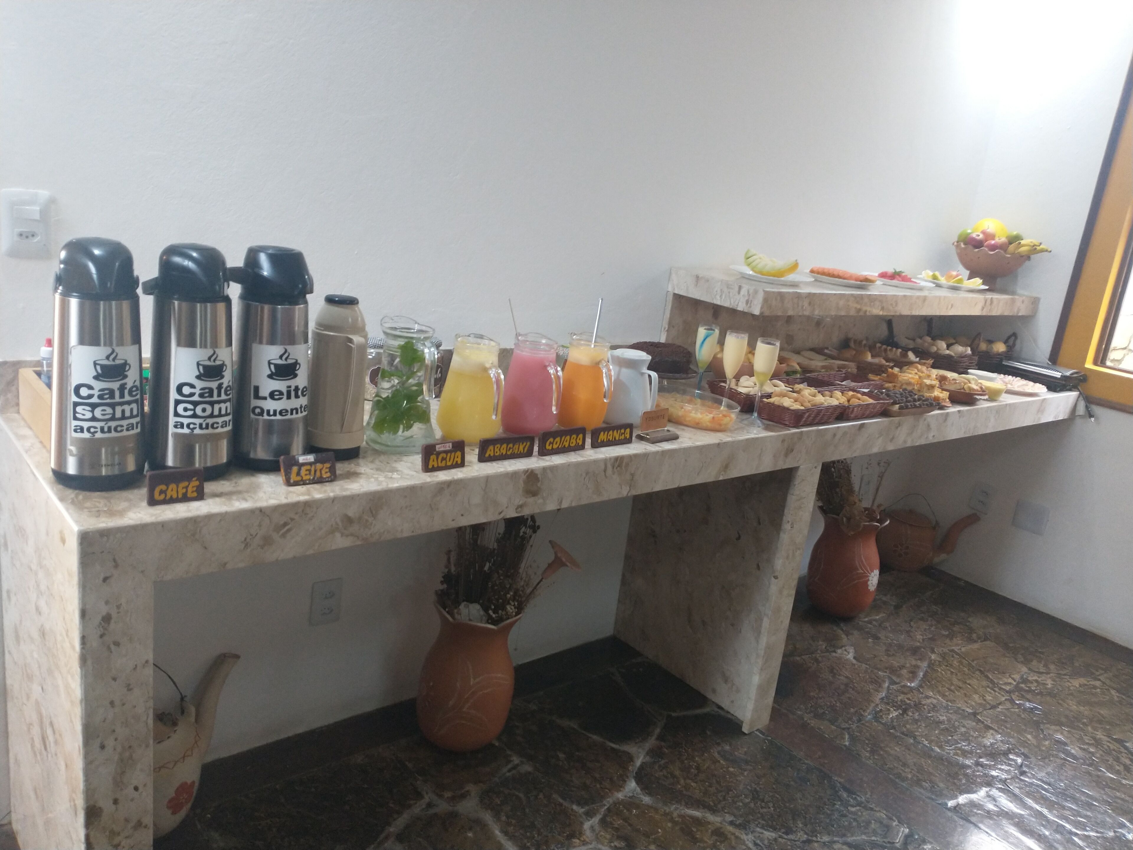 A breakfast buffet with various drinks and pastries.