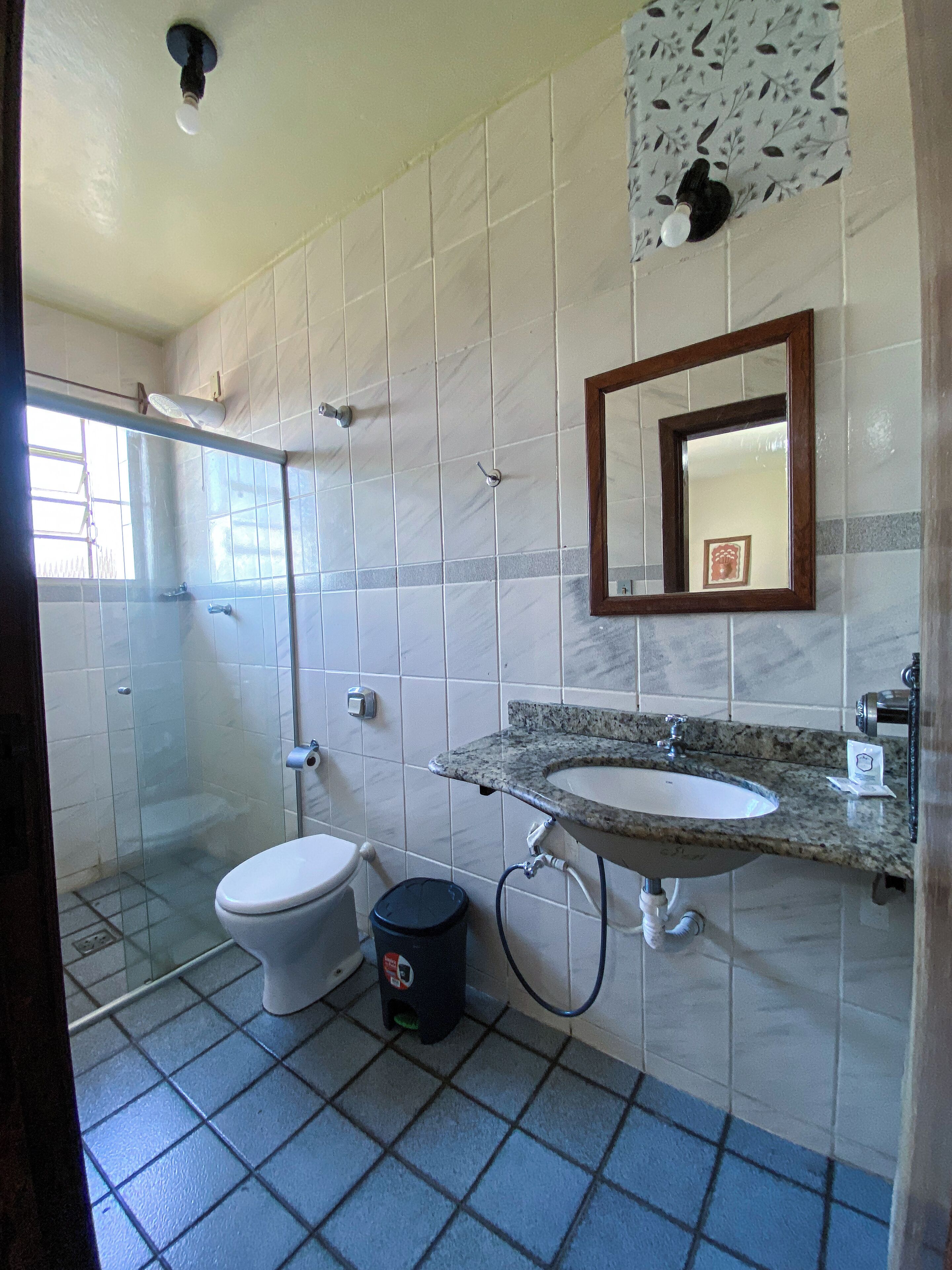 A bathroom with a toilet, sink, and shower.