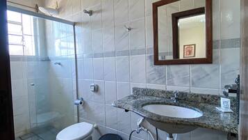 A bathroom with a toilet, sink, and shower.