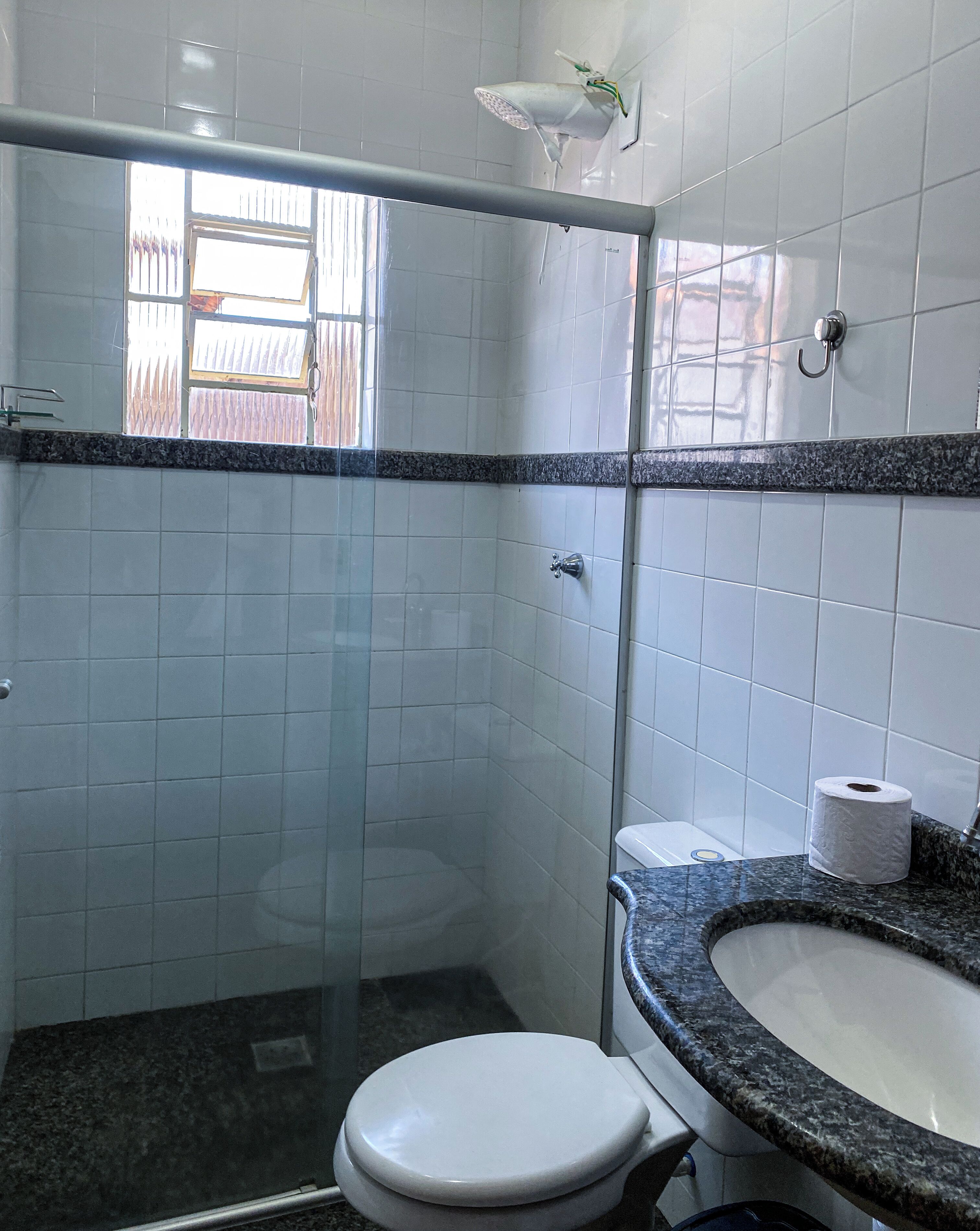 A bathroom with a shower, toilet, and sink.
