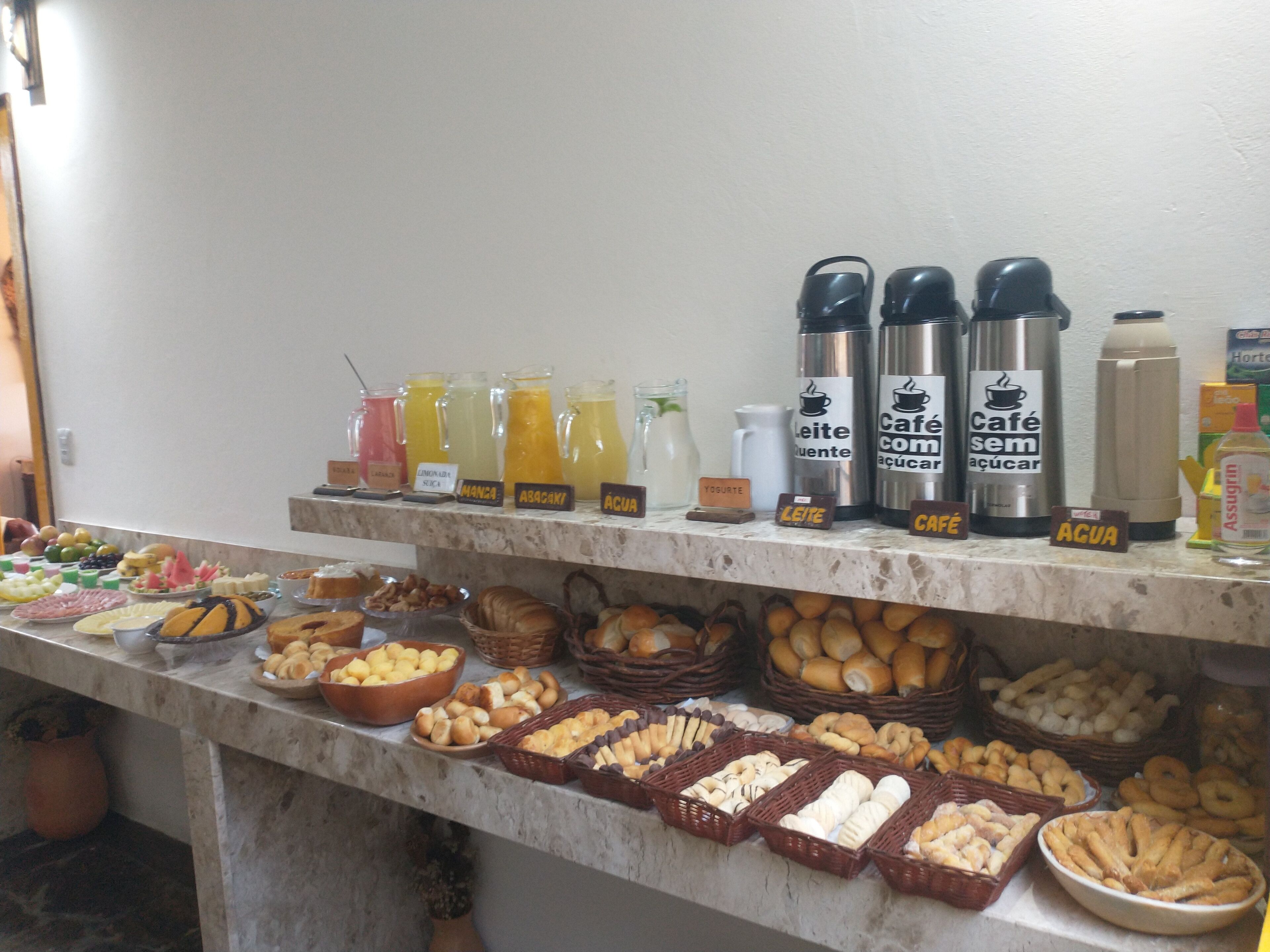 A buffet with various food items and labeled beverage dispensers.