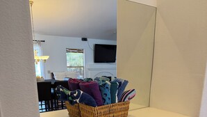 Una cocina con armarios de madera, encimera blanca y una cesta de mimbre llena de toallas.