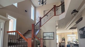 A spacious interior with a wooden staircase, a chandelier, and a dining area. - Great house in Inglewood, walking distance to Zoo, Downtown, Restaurants  (Calgary)