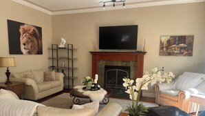 A living room with a fireplace, a television, and a sofa. - Great house in Inglewood, walking distance to Zoo, Downtown, Restaurants  (Calgary)