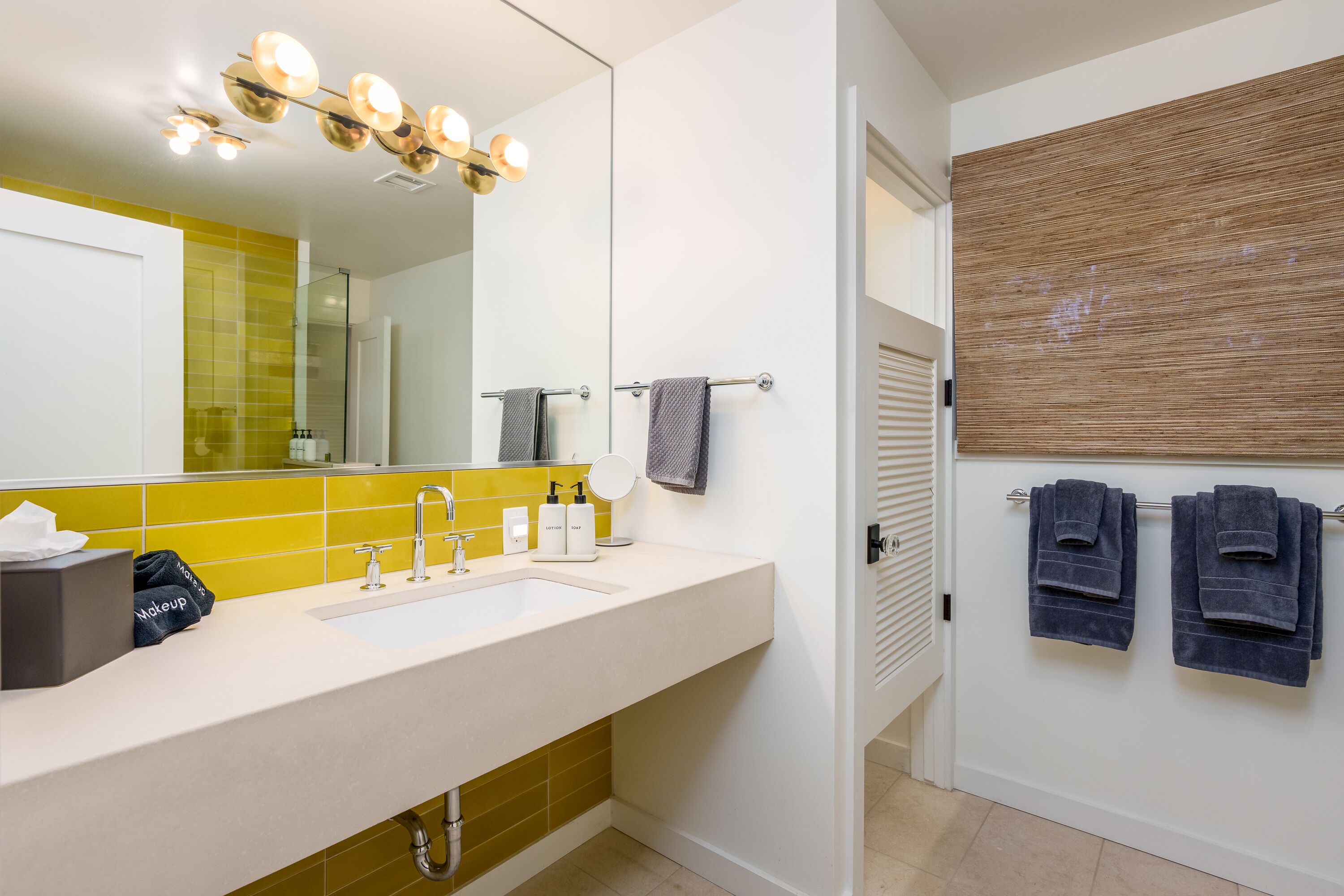 A modern bathroom with a large mirror, a sink, and a towel rack.