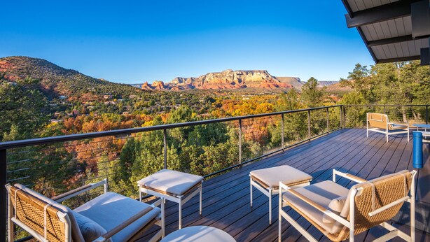 Une terrasse avec des sièges extérieurs et une vue sur un paysage montagneux.