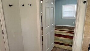 A room with a wooden floor, a white door, and a window with blinds. - The Fort Pierce 

 (Fort Pierce)