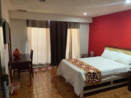 Una habitación con cama, una mesa y una silla.