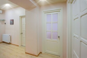 A hallway with white doors, a radiator, and a framed picture on the wall. - H&B apartments Zubalashvili (Tbilisi)