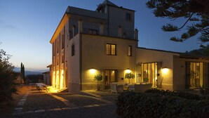 A two-story building with a courtyard, outdoor seating, and a well-lit entrance. - Villa in Gaffe with 19 bedrooms sleeps 36 (Gaffe)