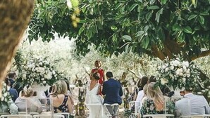 A wedding ceremony under a large tree with guests seated on white chairs facing the aisle. - Villa in Gaffe with 19 bedrooms sleeps 36 (Gaffe)