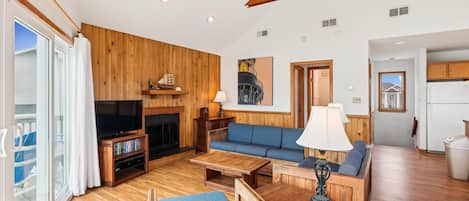 A living room with a television, sofa, and fireplace.