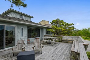 Une maison dotée d’une terrasse, de mobilier d’extérieur et d’une grande fenêtre.