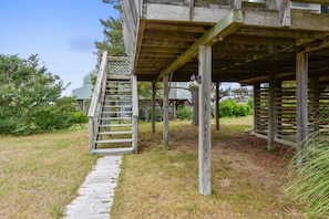 Eine Holzhütte mit einer Holztreppe, die zu einem überdachten Bereich führt.