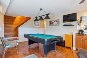 A room with a pool table, a television, and a wooden ceiling. - Carolina Hideaway -- Kitty Hawk Home just steps to the beach with Elevator (Kitty Hawk)
