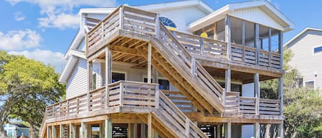 A multi-level wooden structure with outdoor seating and a covered area.