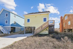 A coastal property with a blue house, a yellow house, and a brown house. - Lovelady -- Pet Friendly Oceanfront with Hot Tub (Kill Devil Hills)