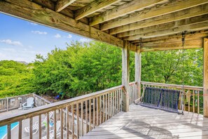 A wooden deck with a view of a swimming pool and lush greenery. - Duck Views-- 4BR Oceanside Duck Home with Private Pool (Duck)