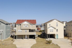 A residential area with two-story houses, a clear sky, and a visible road.