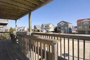 A wooden deck with a railing overlooking a residential area with houses. - School Bored --Affordable Cottage just 2 blocks to the ocean (Kill Devil Hills)