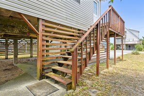 A wooden outdoor staircase leading to a house with a metal roof. - Owl's Nest -- Vacay Your Way with Flexible Arrival and Stay Dates (Kill Devil Hills)