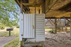 A white utility box with a metal latch, attached to a wooden structure with a metal roof.