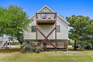A two-story house with a balcony and a wooden staircase leading to the upper floor.