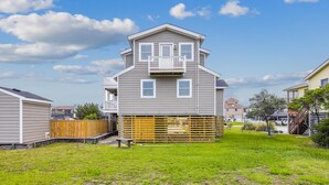 A two-story house with a front porch and a small deck.