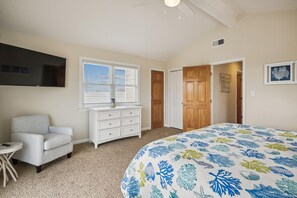 A bedroom with a bed, a dresser, a chair, a TV, and a window with blinds. - Gone to Carolina -- Recently Remodeled Home with Pool, Hot Tub, & Putting Green (Kitty Hawk)