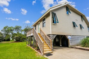 A two-story house with a wooden staircase leading to a porch. - Keepers Loft -- Waterfront Duplex with Pier and Gazebo (Duck)