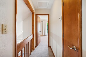 A hallway with a wooden door, a light switch, and a ceiling vent. - Keepers Loft -- Waterfront Duplex with Pier and Gazebo (Duck)