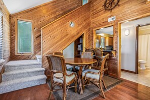 Un interior de madera con comedor, escalera y cocina.