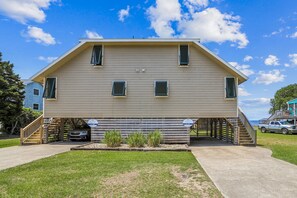 A two-story building with a flat roof, a covered porch, and a staircase leading to the upper level.