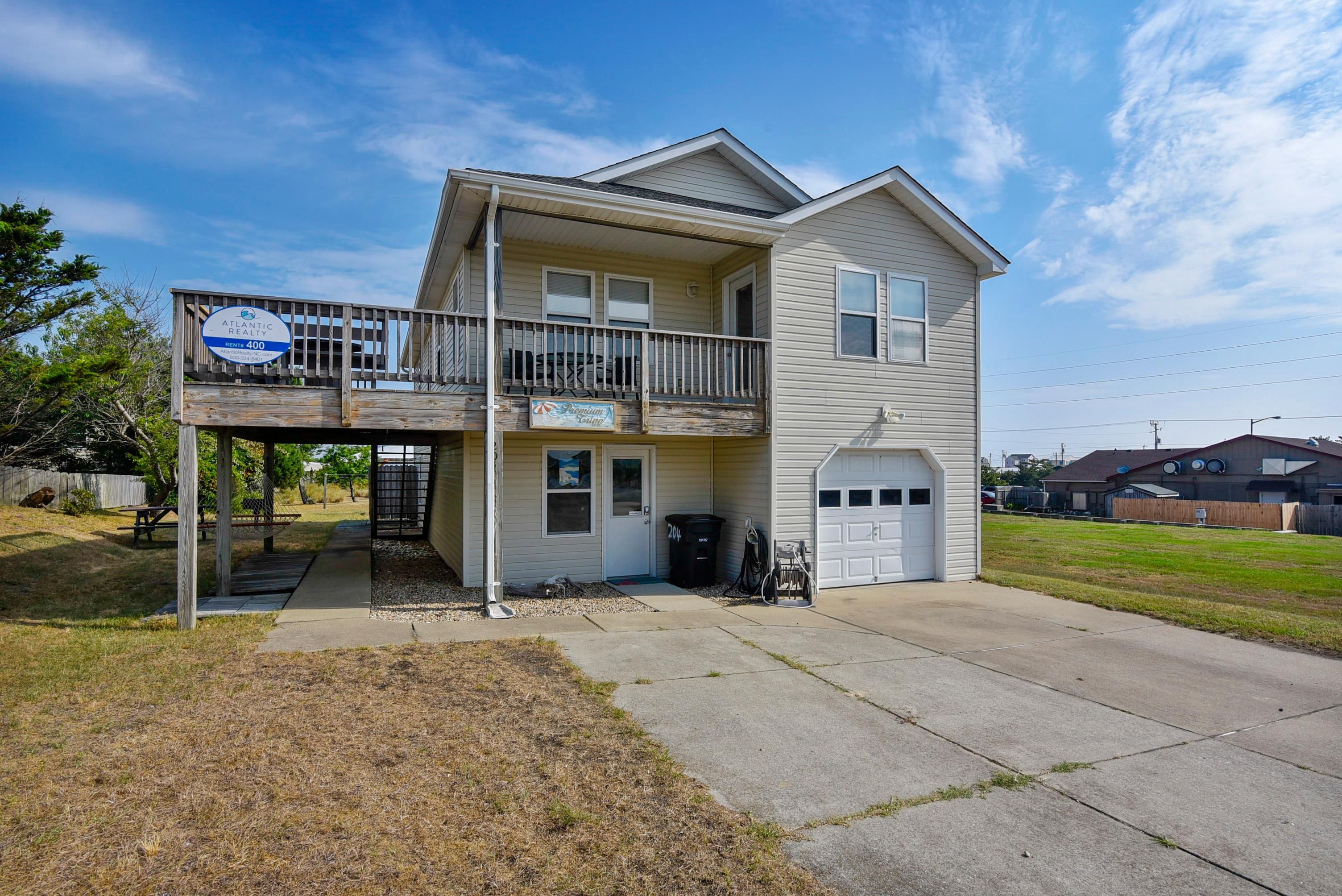A two-story residential building with a balcony, a garage, and a front yard.