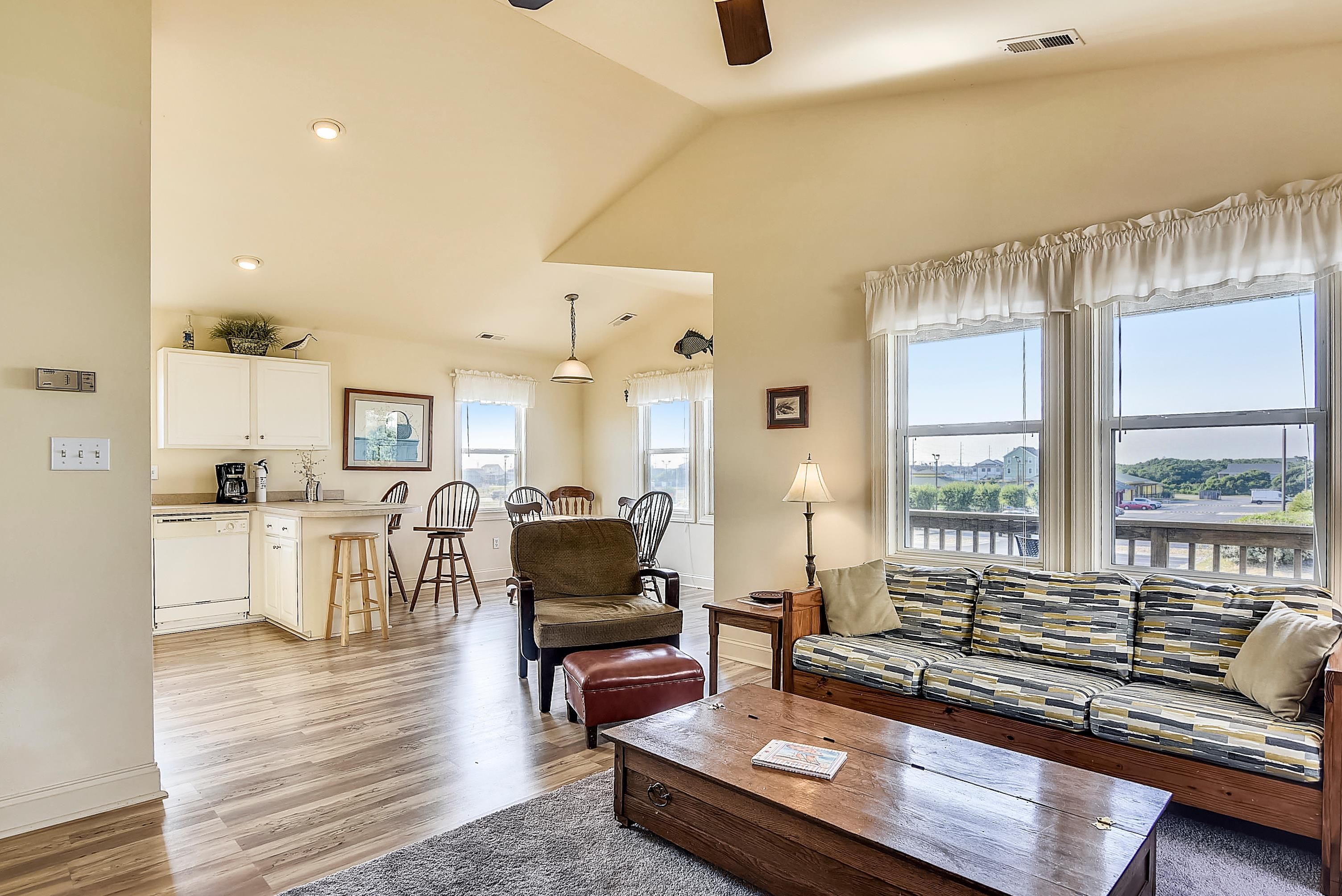 A spacious living area with a sofa, coffee table, and a view of the outdoors.