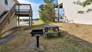 A backyard with a barbecue grill, picnic table, and wooden deck. - Premium Tripp -- Close to Shopping, Restaurants and Activities (Kill Devil Hills)