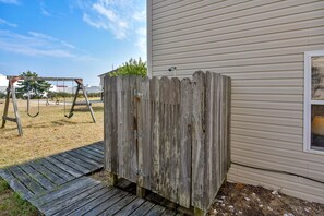 A wooden outdoor utility shed next to a house with a swing set in the background. - Premium Tripp -- Close to Shopping, Restaurants and Activities (Kill Devil Hills)