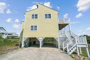 A two-story building with a balcony and a staircase leading to a deck.