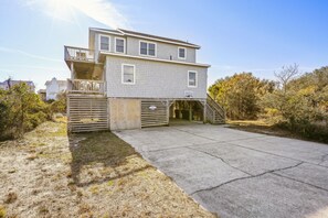 A two-story house with a garage, a covered driveway, and a fenced yard.