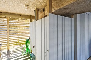 Una estructura de madera con techo de listones y pared blanca con líneas verticales.