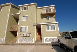 A multi-story residential building with a parking area in front. - Seawalk Unit 14 -- Rare 4BR Oceanfront Townhouse with Pool Access (Kill Devil Hills)