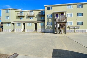 A multi-story motel with a parking lot in front.