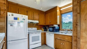 A kitchen with wooden cabinets, a white refrigerator, a stove, and a dishwasher. - Timberland -- 4 BR Oceanside home in Southern Duck (Duck)
