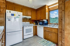 A kitchen with wooden cabinets, a white refrigerator, a stove, and a dishwasher. - Timberland -- 4 BR Oceanside home in Southern Duck (Duck)