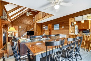 A wooden interior with a dining area, kitchen, and a staircase. - Timberland -- 4 BR Oceanside home in Southern Duck (Duck)