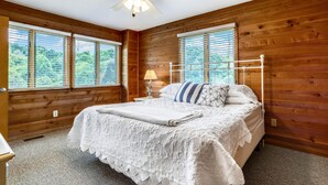 A bedroom with a bed, a nightstand, a lamp, and a ceiling fan. - Timberland -- 4 BR Oceanside home in Southern Duck (Duck)
