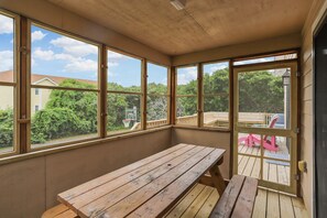 A wooden deck with a picnic table and a door leading to a screened outdoor area. - Timberland -- 4 BR Oceanside home in Southern Duck (Duck)